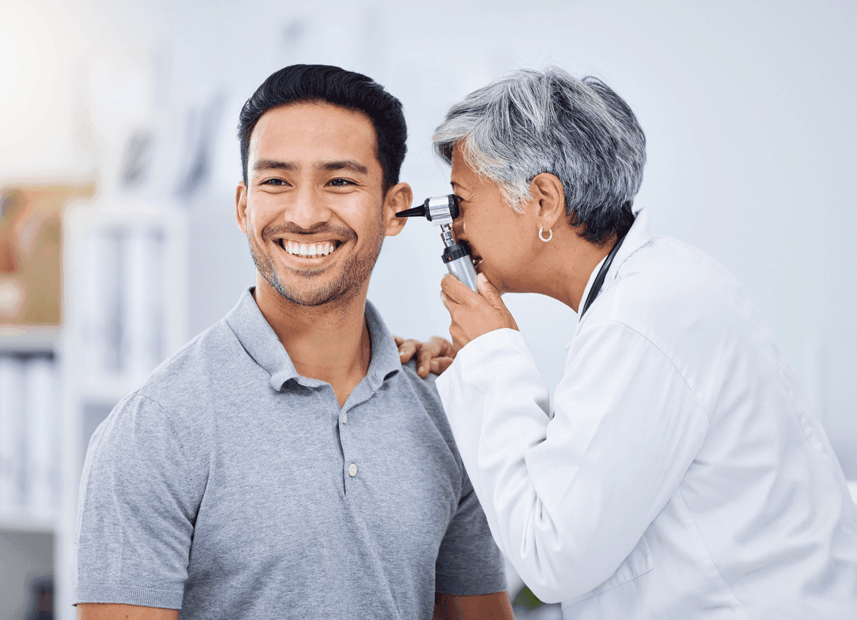 Audiologist preparing a hearing aid for a patient