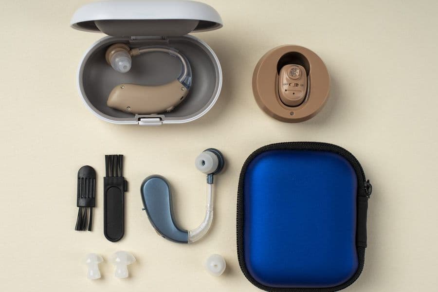 Starter hearing aid kit with behind-the-ear and in-the-ear devices, cleaning tools, ear tips, and a carrying case