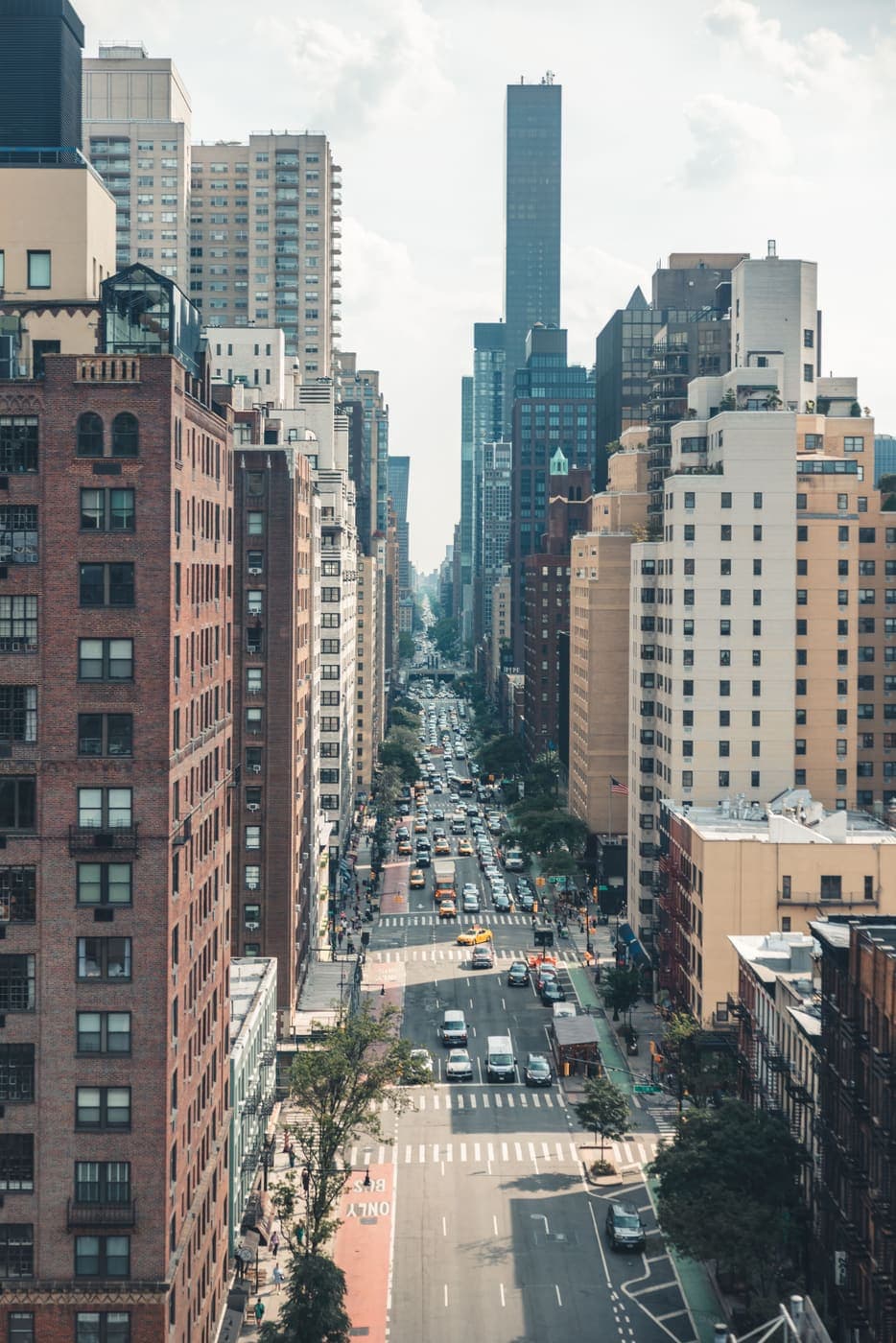 Aerial view of a busy New York City avenue lined with tall buildings